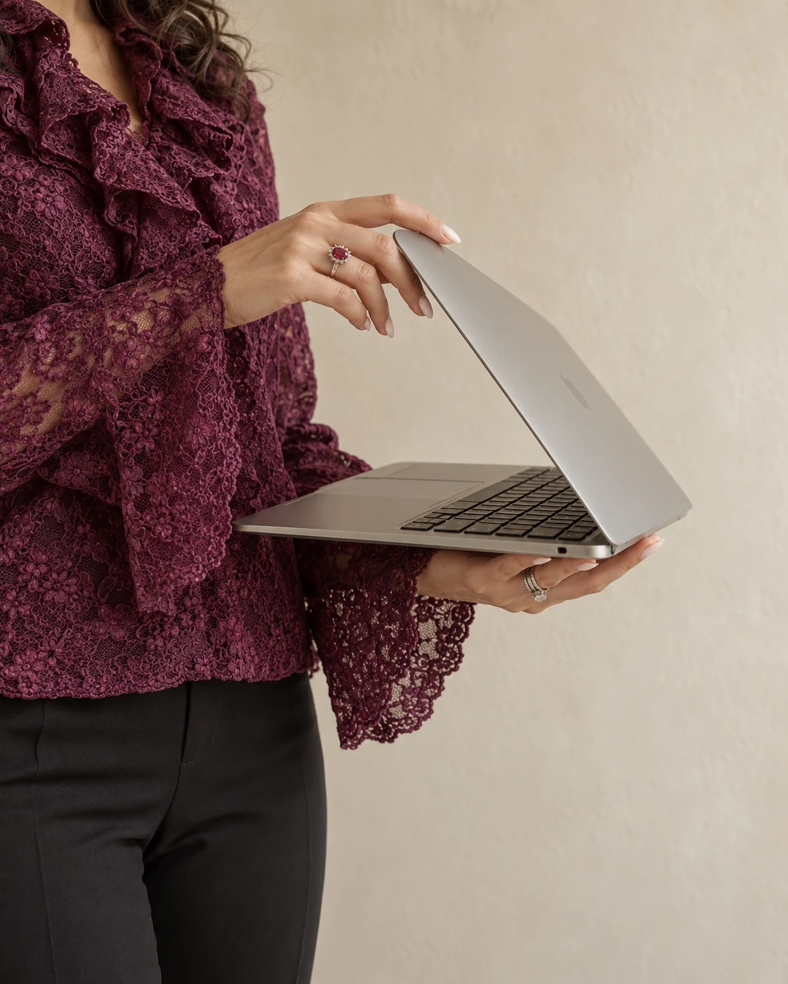 Lucrezia con una blusa cremisi mentre tiene un computer portatile